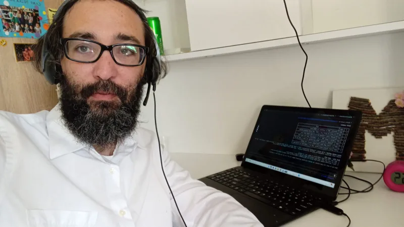 Zechariah Tokar working at his laptop with a headset