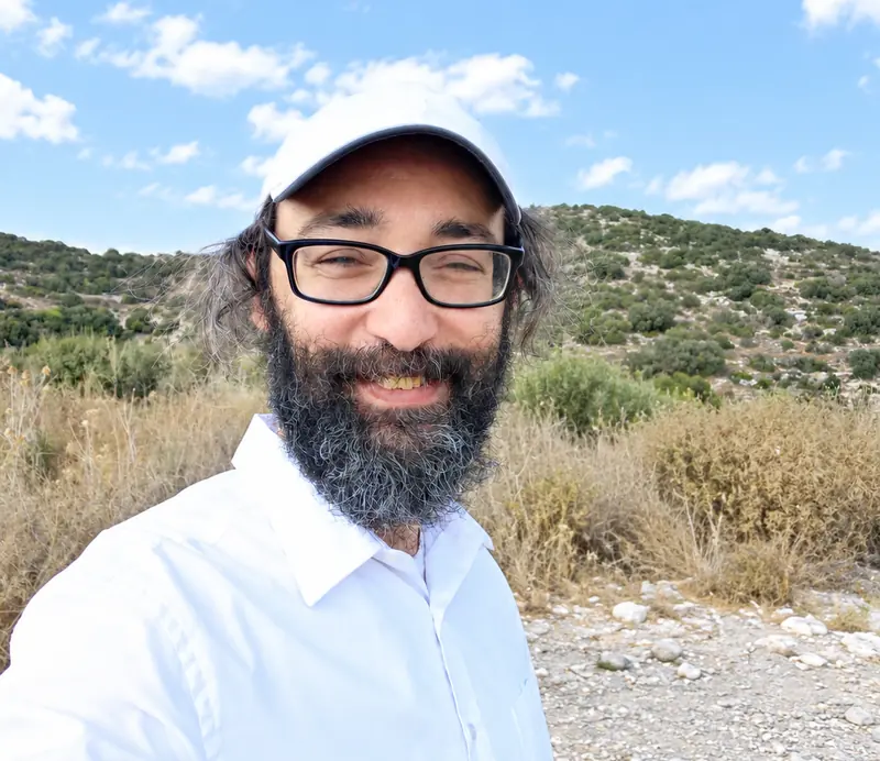 Zechariah Tokar smiling outdoors in a white cap and shirt